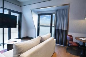 a living room with a couch and a large window at Canopy By Hilton Istanbul Taksim in Istanbul