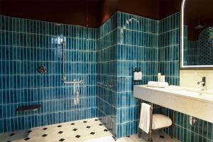 a bathroom with blue tiled walls and a shower at Canopy By Hilton Istanbul Taksim in Istanbul +21 photos