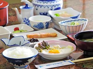 ŌsasuにあるAnori Seaside Hotelの食べ物を盛ったボウルや皿が置かれたテーブル
