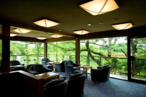 a waiting room with chairs and tables and large windows at Shigisan Kanko Hotel in Sango