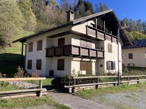 a white house with a wooden fence in front of it at 031 Trilocale piano terra, Giustino in Giustino