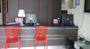 two red chairs in front of a counter with computers at De Mesra Villa in Kampung Sena +11 photos