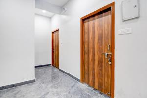 due porte in legno in una stanza con pareti bianche di Hotel O Ayesha Palace a Bārang