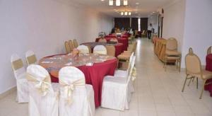 a row of tables and chairs with red and white bows at Hotel Zamburger Segamat (Previously Koptown Hotel Segamat) in Segamat