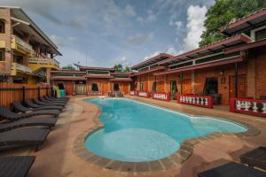 a large swimming pool with lounge chairs around it at Pongphen Guesthouse in Kanchanaburi City