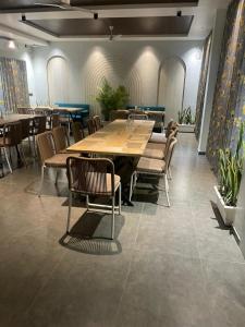 Un comedor con una gran mesa y sillas de madera. en Precesion Palace Suites Near Delhi Airport, en Nueva Delhi
