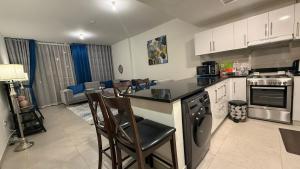 a kitchen with a counter and some chairs in it at Sea-View 1BR in Saadiyat - Pool - GYM - Free Parking in Abu Dhabi