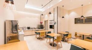 a restaurant with tables and chairs and a kitchen at City Comfort Inn Guangzhou Zengcheng Wanda Plaza Metro Station in Zengcheng