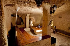 uma casa de banho de estilo gruta com uma banheira e uma mesa em Adanos Konuk Evi em Avanos