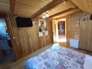 a bedroom in a log cabin with a bed at Casa Utan in Văleni