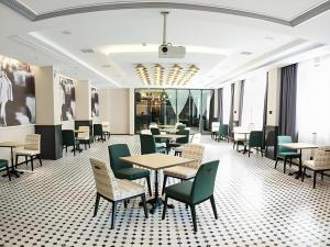 a dining room with tables and chairs and windows at City Comfort Premier Hotel Xiaogan Anlu Railway Station Dongda Times Square in Teianfu