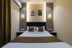 Un dormitorio con una gran cama blanca con dos almohadas. en Hotel Metroplex Near BKC, en Bombay