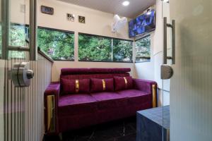 Sofá púrpura en una habitación con ventanas en Hotel Metroplex Near BKC, en Bombay