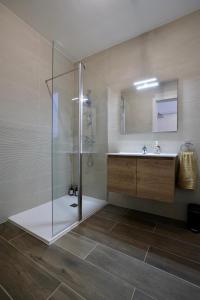 a bathroom with a glass shower and a sink at St Paul's Apt Distant SeaViews in St. Paul's Bay +40 photos