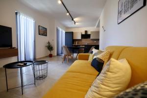 a living room with a yellow couch and a table at St Paul's Apt Distant SeaViews in St. Paul's Bay