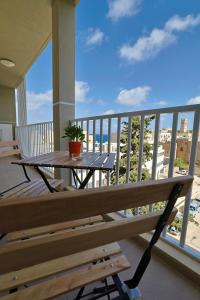 a balcony with a table and a view of the beach at St Paul's Apt Distant SeaViews in St. Paul's Bay