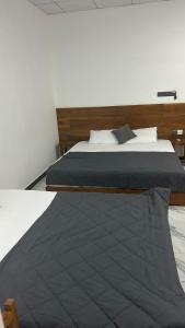 een slaapkamer met een groot bed met een houten hoofdeinde bij Green inn Trinco in Uppuveli