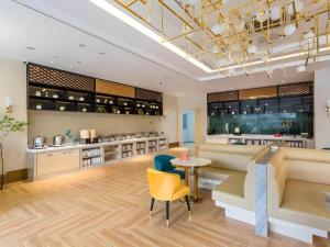 a kitchen with a table and chairs and a counter at Magnotel Business Yangzhou China Grand Canal Museum Wanda Plaza in Yangzhou