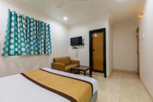 a hotel room with a bed and a chair at Hotel Stay Land Inn Versova in Mumbai