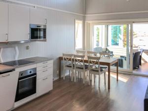 a kitchen and dining room with a table and chairs at 6 person holiday home in Dyrvik in Dyrvik
