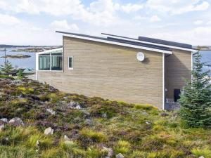 une maison au sommet d'une colline avec de l'eau dans l'établissement 6 person holiday home in Dyrvik, à Dyrvik