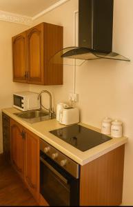 a kitchen with a sink and a microwave at Elegant Vintage Stay Near Airport & NEC in Birmingham