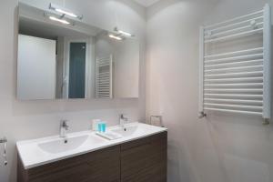 łazienka z białą umywalką i lustrem w obiekcie La Terrace - IB. Apartments w mieście San Sebastián +16 zdjęć