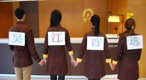 a group of people holding hands in front of a counter at IU Hotel Wujiang Huadong Business City Tongli in Suzhou