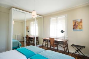sypialnia z łóżkiem, stołem i krzesłami w obiekcie La Terrace - IB. Apartments w mieście San Sebastián