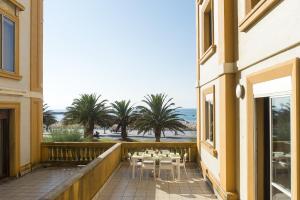 balkon ze stołami, krzesłami i palmami w obiekcie La Terrace - IB. Apartments w mieście San Sebastián