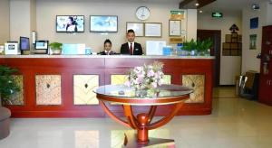 a man and a woman standing at a counter in a store at GreenTree Inn Tianjin JinNan ShuangLin Metro Station Express Hotel in Tianjin +217 photos