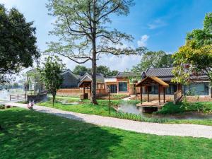 a house with a tree and a walkway at Chaoyangli Folk Resort Hotel in Zhaoqing