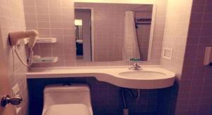 a bathroom with a sink and a toilet and a mirror at Jinjiang Inn Baoding Baigou Town in Yihezhuang +62 photos