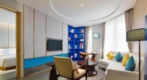 a living room with a couch and a tv in a room at Four Points by Sheraton Haikou International Airport in Haikou