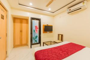 a bedroom with a red bed and a tv at Hotel Stay Land Inn Versova in Mumbai +30 photos