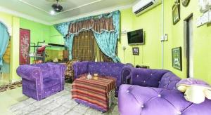 a living room with purple furniture and a purple couch at OYO 90740 Paddington Lodge in Kubang Kerian