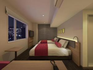 a bedroom with a bed and a desk and a window at KEIKYU EX INN Hamamatsucho Daimon-Station (Tokyo) in Tokyo