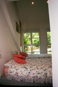 a bedroom with a bed with red pillows and a window at Loft de Cannes B&B in Cannes