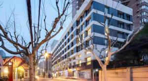 a building on a street with trees in front of it at base-WENDING Service Apartment-Shanghai Xujiahui Location in Shanghai