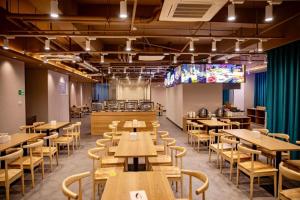a restaurant with wooden tables and chairs and a screen at Liyuan Hotel in Shenzhen