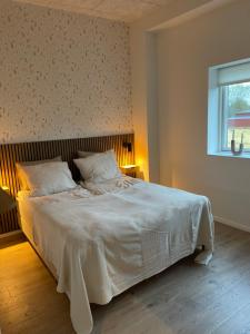 a bedroom with a large white bed with a window at Beauty sleep Guldager in Esbjerg
