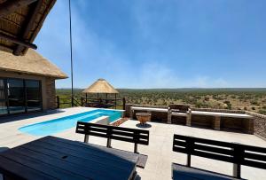 a villa with a swimming pool with a view at Pezulu Lodge in Warmbaths