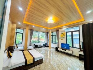 HeniSi 2 Hotel Măng Đen في Kon Von Kla: غرفة نوم بها سريرين وتلفزيون بشاشة مسطحة