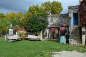 a yard with two beds in front of a house at Fabetmie in Mormoiron