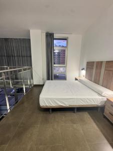 a bedroom with a large bed and a window at Palm Suites Gran Vía in Alicante