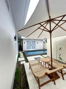 a patio with two chairs and an umbrella at Amed Happy House in Amed +5 photos