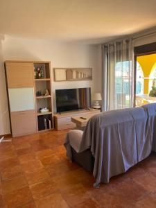 a living room with a bed and a television at Beautiful apartment with gardens - sea and mountain views in Isla Plana