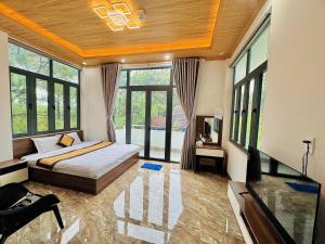 HeniSi 2 Hotel Măng Đen في Kon Von Kla: غرفة نوم بسرير وتلفزيون ونوافذ +14 صورة