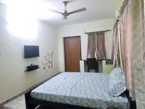 コインバトールにあるVPM Homestayのベッドと天井扇風機のある寝室