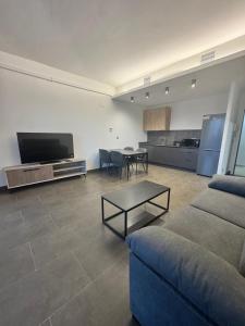 a living room with a couch and a table and a kitchen at Palm Suites Gran Vía in Alicante